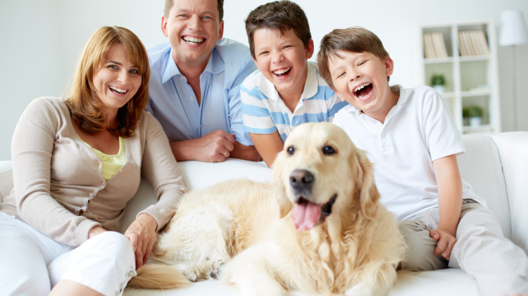 Portrait of happy family with their pet having good time at home